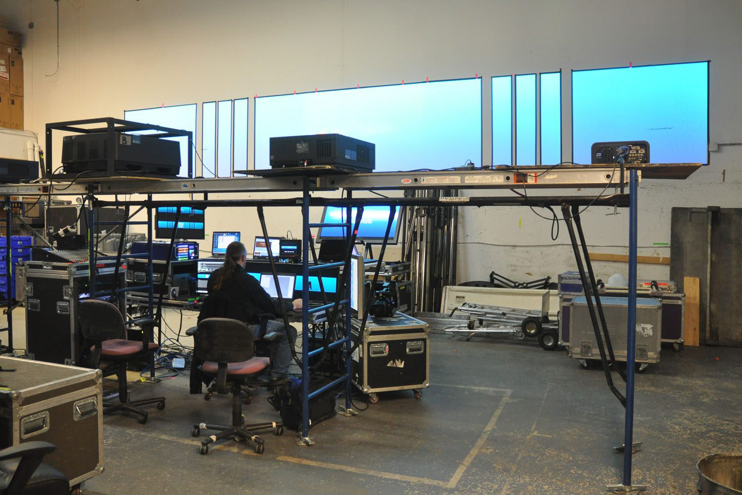 AV specialist preparing for event behind the scenes on computer